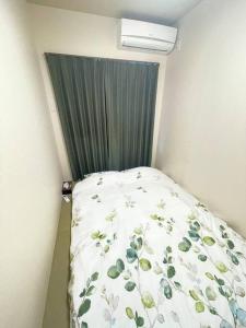大阪的住宿－茶隐の宿，小卧室配有一张带绿帘的床