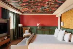 セビリアにあるHotel Colón Gran Meliá - The Leading Hotels of the Worldのベッドルーム1室(ベッド1台付)が備わります。天井に絵画が飾られています。