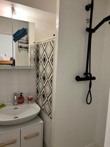W łazience znajduje się umywalka i lustro. w obiekcie Cosy renovated Studio balcony Andromède w mieście Vénosc