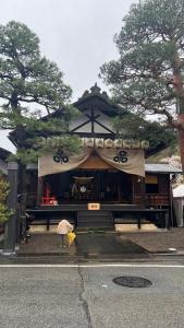 una persona è in piedi di fronte ad un santuario di JAS HOTEL TAKAYAMA a Takayama