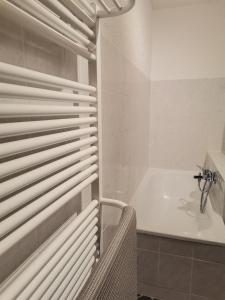La salle de bains blanche est pourvue d'une baignoire, d'une douche et d'une fenêtre. dans l'établissement Auszeit, à Freital