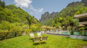 a resort yard with chairs and a swimming pool at Homeward Mountain Resort in Zhangjiajie