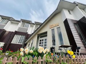 una casa con dei fiori davanti di JAS HOTEL TAKAYAMA a Takayama