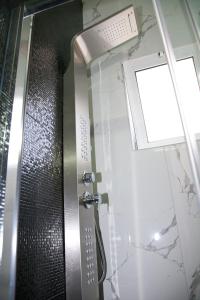 una doccia con porta in vetro e finestra di Chris Luxury Studio a Ioannina
