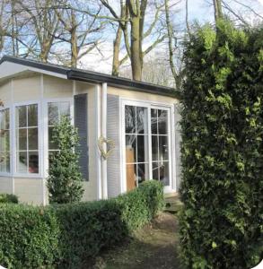 uma pequena casa com uma janela e um arbusto em Vakantie veluwe em Wageningen