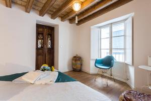 - une chambre avec un lit et une chaise bleue dans l'établissement Catedral Encantador 1 Dormitorio 1 Baño, à Cadix