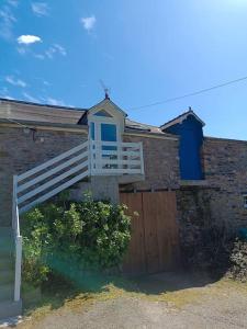 una casa con una puerta de madera y una puerta blanca en Gite au calme près de Quimper. en Landrévarzec