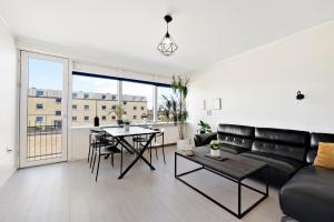 sala de estar con sofá y mesa en Moderne lejlighed med privat parkering, en Randers