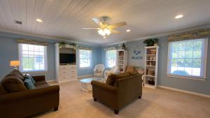 a living room with two couches and a ceiling fan at LYONS DEN - 3 Bedroom Home home in Jekyll Island