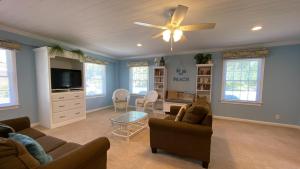 a living room with a couch and a ceiling fan at LYONS DEN - 3 Bedroom Home home in Jekyll Island