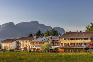 a group of buildings with mountains in the background at Alm- & Wellnesshotel Alpenhof in Schönau am Königssee