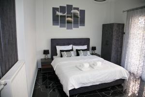 una camera da letto con un grande letto bianco con due asciugamani di Chris Luxury Studio a Ioannina