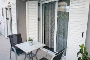 un tavolo e sedie su un portico con finestra di Chris Luxury Studio a Ioannina