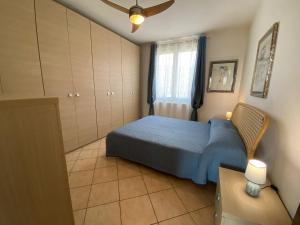 a bedroom with a blue bed and a window at Melograno in Feriolo in Baveno