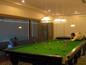 a man sitting in front of a pool table at Paradise Isle Beach Resort in Udupi