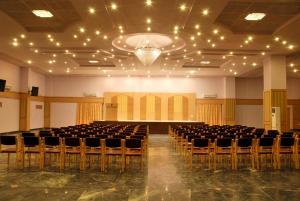 an empty hall with rows of chairs and a chandelier at Paradise Isle Beach Resort in Udupi +21 photos