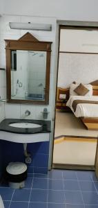 a bathroom with a sink and a toilet and a bed at Amidhara Resort in Sasan Gir