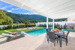 a patio with a table and chairs and a swimming pool at Villa Myrto in Ialyssos