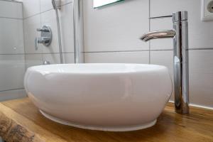 a white sink sitting on a wooden counter in a bathroom at Uferpromenade Whg OG in Röbel +22 photos