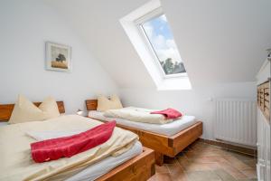 two twin beds in a room with a window at Uferpromenade Whg OG in Röbel
