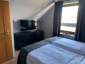 a bedroom with a bed and a flat screen tv at MeerEncore, Hohenzollernstr. 30 in Büsum