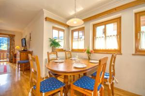 Un comedor con mesa y sillas de madera. en Select Top 4 - by Alpen Apartments, en Piesendorf