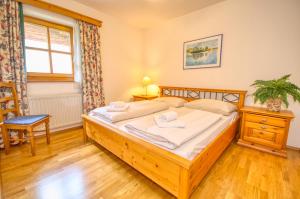 1 dormitorio con cama de madera y ventana en Select Top 4 - by Alpen Apartments, en Piesendorf 15 fotos más