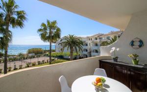 a balcony with a table and a view of the ocean at PRIMERA LINEA Playa Romana Frontal al Mar ALBERT VILLAS in Alcossebre