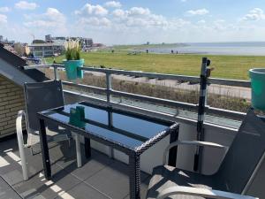 a table on a balcony with a view of the beach at MeerEncore, Hohenzollernstr. 30 in Büsum