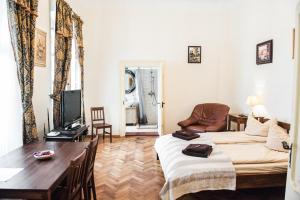 a room with two beds and a table and a tv at Brukenthal Central Apartments Sibiu in Sibiu