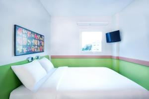 um quarto com uma cama branca e uma janela em Ibis Budget Semarang Tendean - CHSE Certified em Semarang