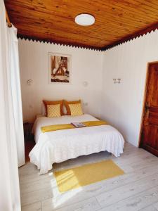 1 dormitorio con cama y techo de madera en Les Tables Aux Vaches - Maison d'Hôtes - Table d'Hôtes sous conditions, en La Salvetat-sur-Agout