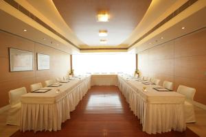 a row of tables in a room with white chairs at Jaypee Siddharth in New Delhi