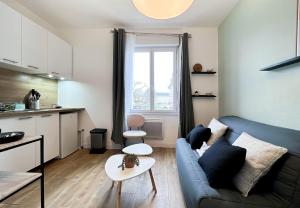ein Wohnzimmer mit einem blauen Sofa und einer Küche in der Unterkunft Le studio 37 - Cœur de Rennes - Proche gare in Rennes