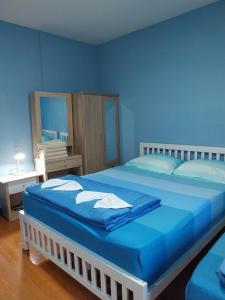 a blue bedroom with a large bed with blue sheets at Home of River Kwai in Kanchanaburi