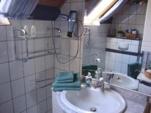 a bathroom sink with a green towel on it at Eifelferienwohnungen "Familie Saxler" in Bereborn