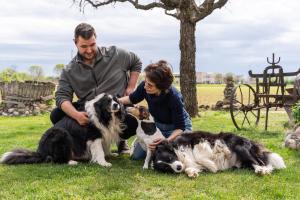 un hombre y una mujer jugando con dos perros en Agriturismo Pozzo Fiorito en Castiglione delle Stiviere