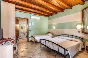 a room with two beds and a bathroom at Agriturismo Pozzo Fiorito in Castiglione delle Stiviere