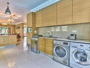 a kitchen with a washer and dryer in it at Villa Jesdene in Cape Town