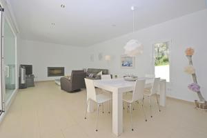 biała jadalnia z białym stołem i krzesłami w obiekcie Villa Carritx 4 pax w mieście Capdepera