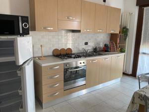 a kitchen with wooden cabinets and a stove top oven at Da Tonio in Lodi