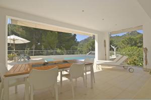 comedor con mesa, sillas y piscina en Villa Carritx, en Capdepera