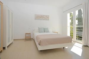 Un dormitorio blanco con una cama y una ventana. en Villa Carritx, en Capdepera 38 fotos más
