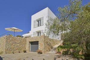 una casa blanca con un muro de piedra en Villa Carritx, en Capdepera