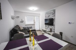 un soggiorno con un tavolo e un divano di Apartment Ma&Ja with Hot Tub a Metlika