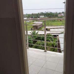 eine Tür zu einem Balkon mit Blick auf ein Feld in der Unterkunft Traveler House in Dimapur