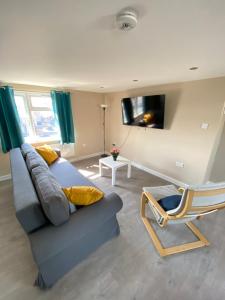 ein Wohnzimmer mit einem Sofa und einem Stuhl in der Unterkunft STUNNING 1 BEDROOM FLAT IN WOOD GREEN in London