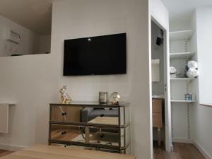 sala de estar con TV de pantalla plana en la pared en Studio Centre de Foix, en Foix