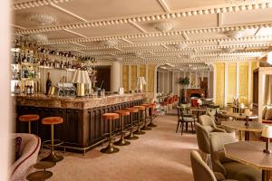 巴黎Château des Fleurs Hôtel & Spa Paris的餐厅里的酒吧，配有桌椅