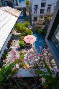 uma vista para um jardim com um guarda-sol e flores em Life Boutique Hotel em Hue